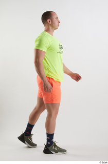 Joel  1 dressed green sneakers orange shorts side view…